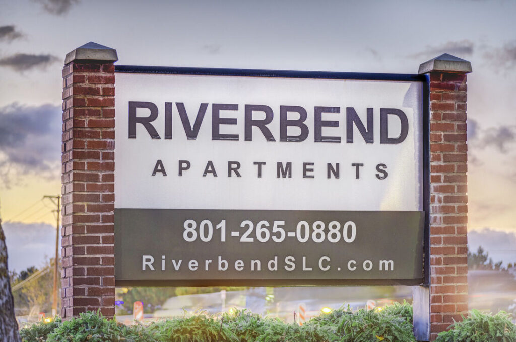 Property sign that reads Riverbend Apartments 801 265 0880 River bend s l c dot com