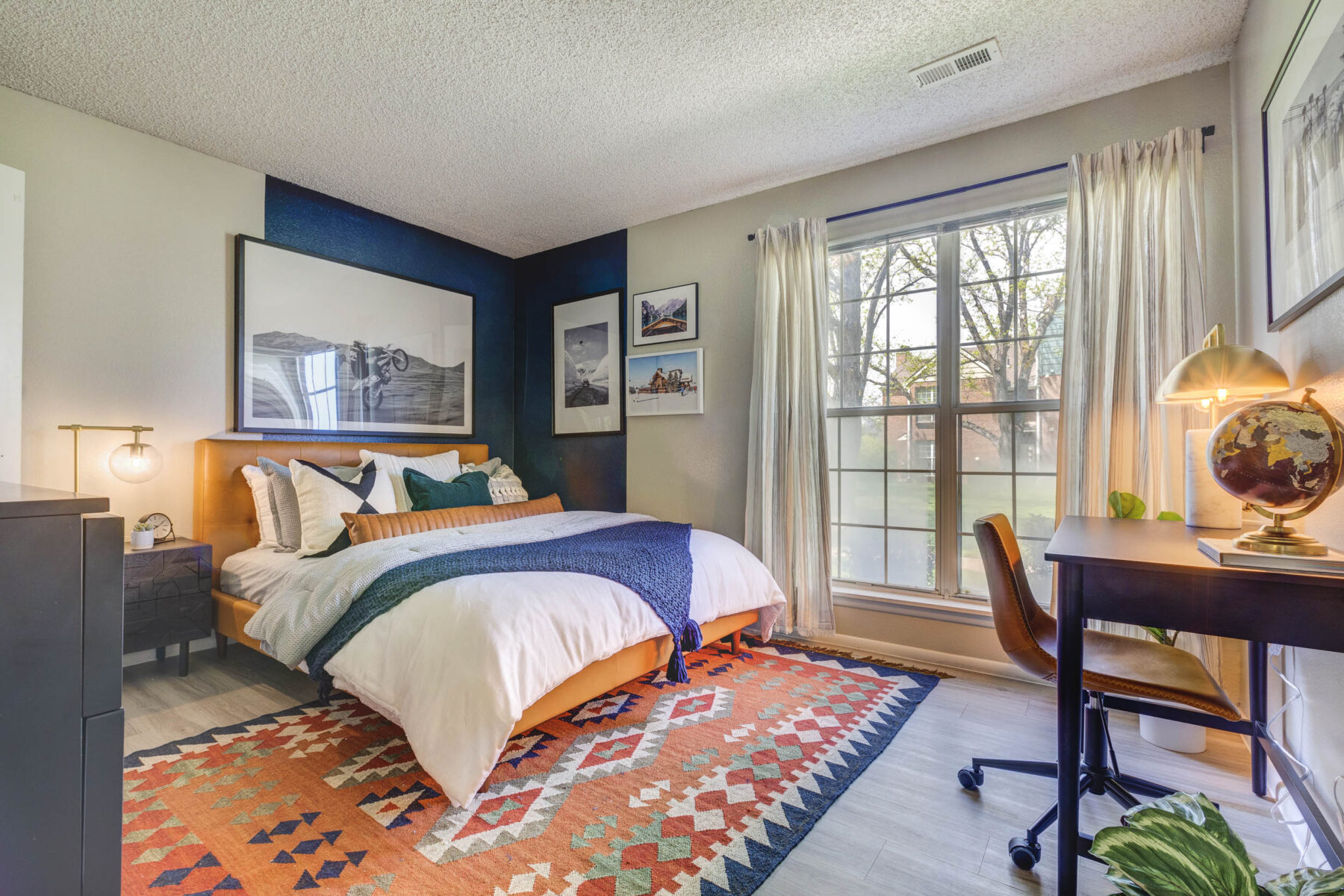 Staged bedroom with large window and two tone accent wall